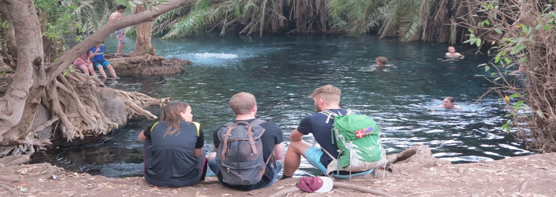 Chemka kikuletwa hot springs visitors relaxing beside clear blue water tanzania
