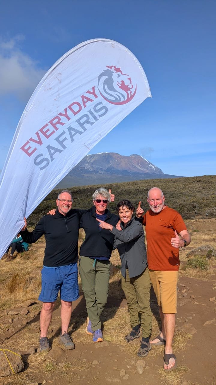 Everyday Safaris Kilimanjaro trekking team with branded flag in Tanzania