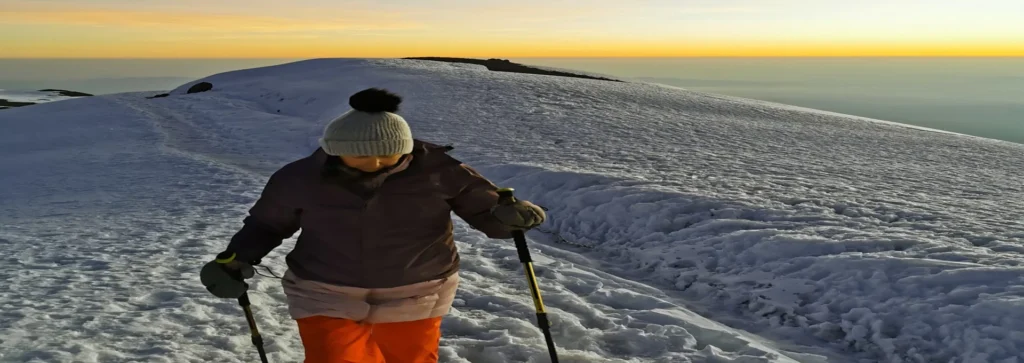 Kilimanjaro lemosho route climber crossing snowy high altitude ridge