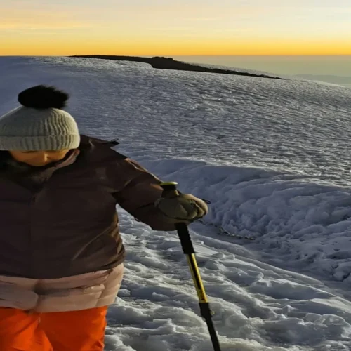 Kilimanjaro lemosho route climber crossing snowy high altitude ridge