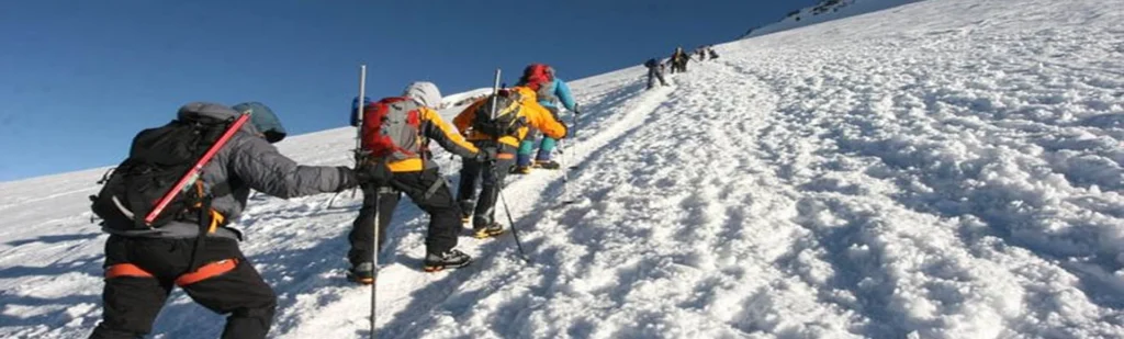 Kilimanjaro northern circuit climbers crossing snow covered high altitude ridge