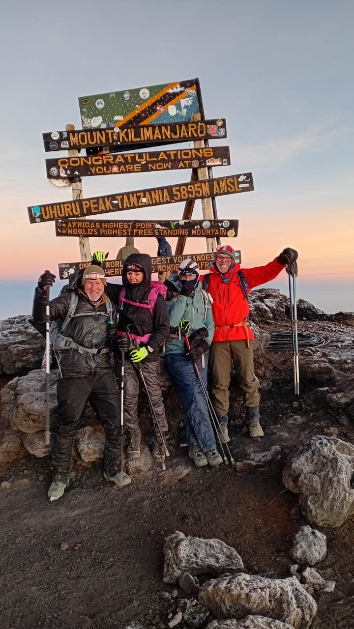 Kilimanjaro climbers celebrating at Uhuru Peak before continuing their Tanzania adventure