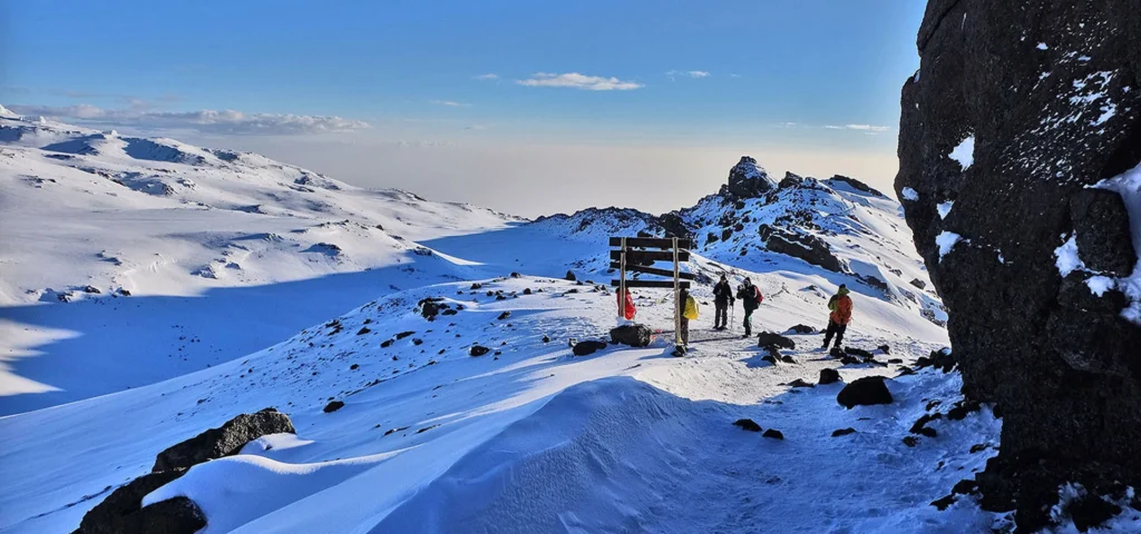 Kilimanjaro umbwe route climbers crossing snow covered high altitude trail