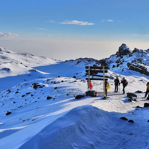 Kilimanjaro umbwe route climbers crossing snow covered high altitude trail