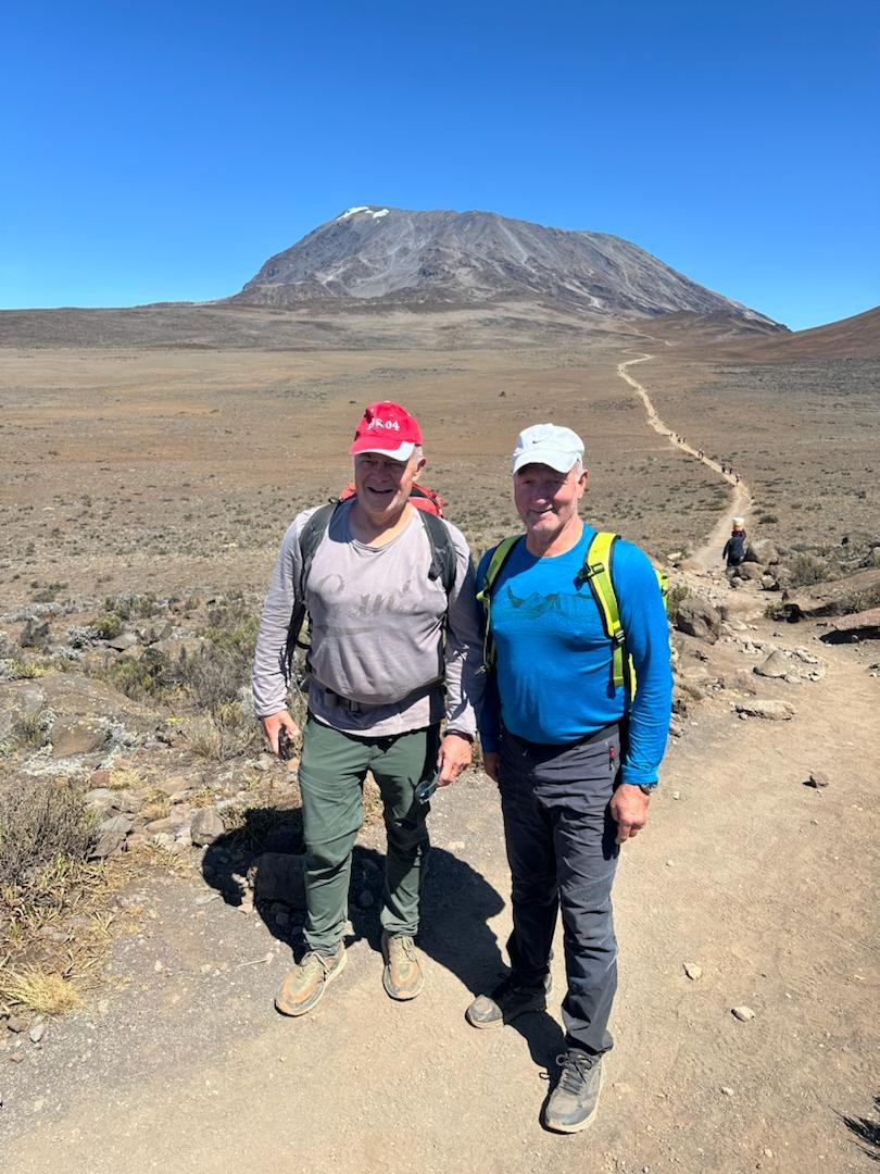 Two trekkers walking toward Kibo on Mount Kilimanjaro