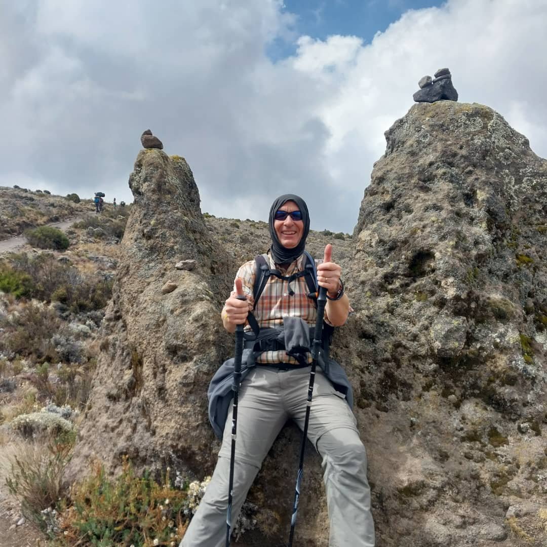 Private Kilimanjaro climber beside volcanic rock at high altitude