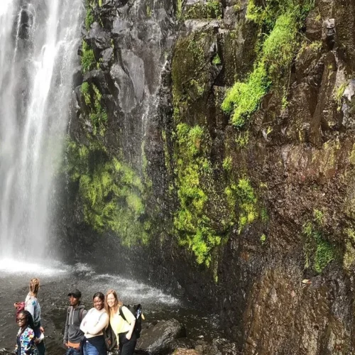 Materuni waterfall visitors beneath scenic cascade near kilimanjaro tanzania