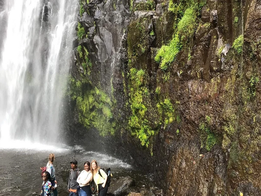 Materuni waterfall visitors beneath scenic cascade near kilimanjaro tanzania