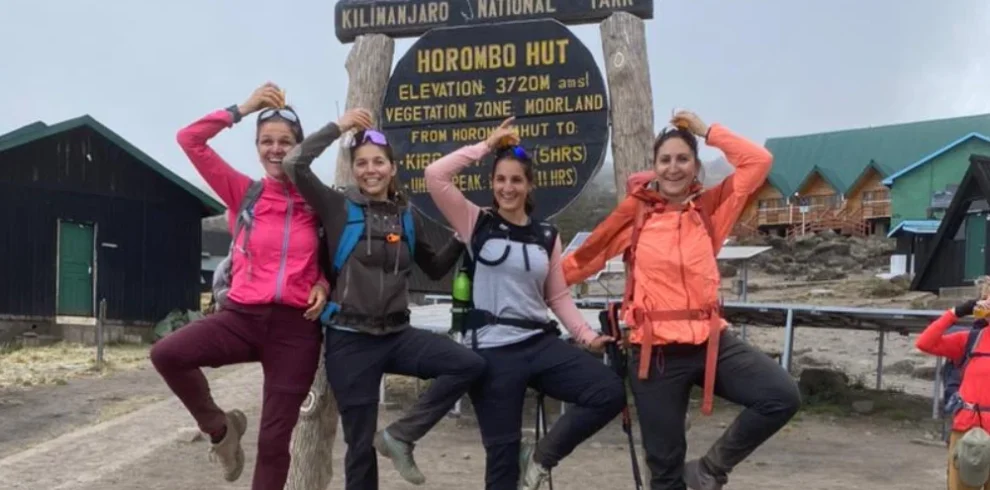Mount meru climbers at saddle hut route sign in arusha national park