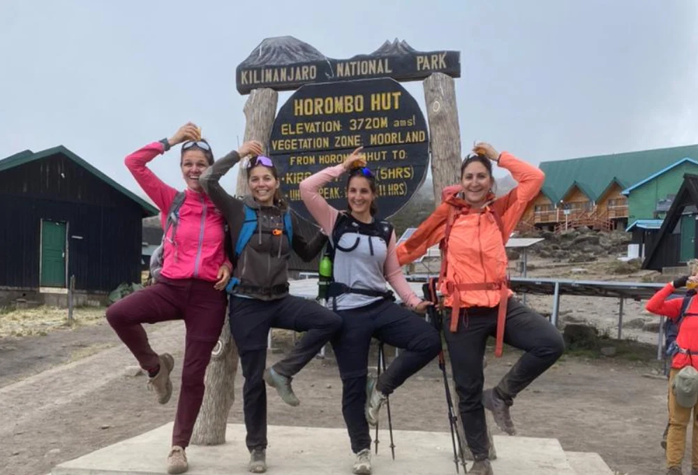 Mount meru climbers at saddle hut route sign in arusha national park