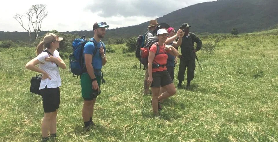 Mount meru trekkers crossing highland grassland on momella route tanzania
