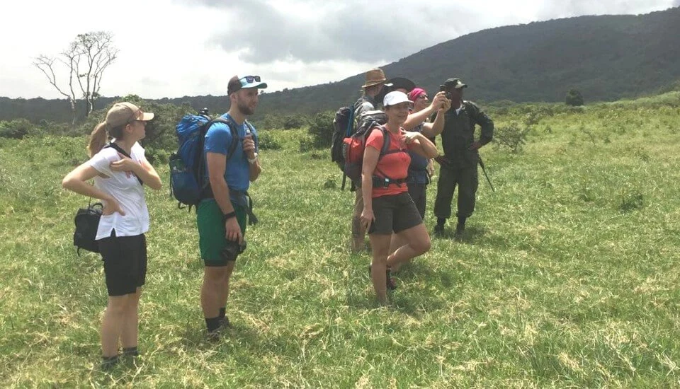 Mount meru trekkers crossing highland grassland on momella route tanzania