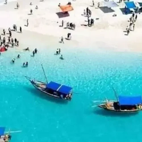 Aerial view of a Zanzibar white sand beach with turquoise water and local boats