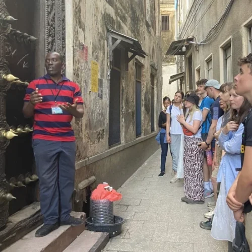 Visitors walking through a historic narrow street in Stone Town Zanzibar