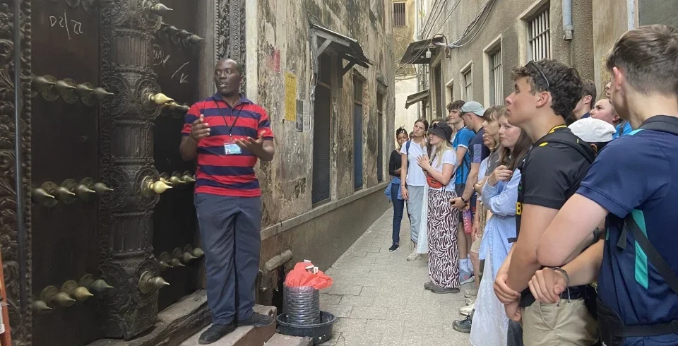 Visitors walking through a historic narrow street in Stone Town Zanzibar