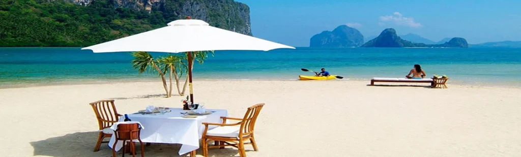 White sand Zanzibar beach with sun loungers palm trees and turquoise Indian Ocean