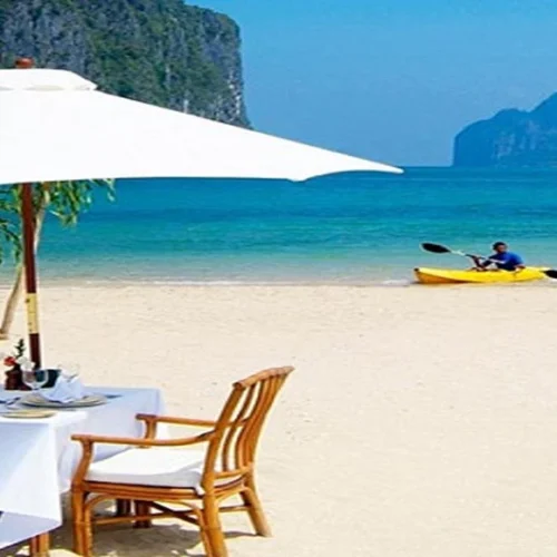 White sand Zanzibar beach with sun loungers palm trees and turquoise Indian Ocean