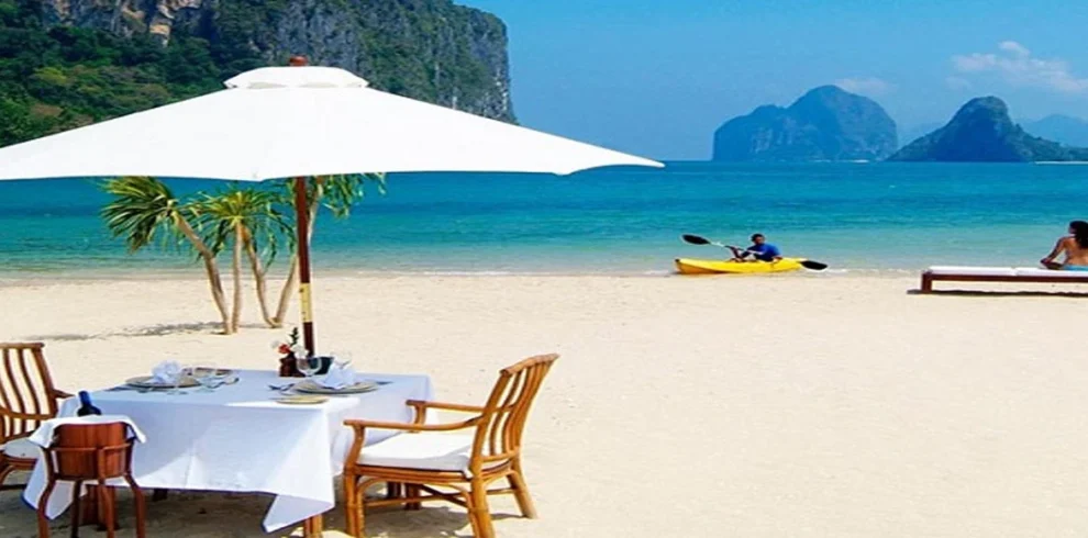 White sand Zanzibar beach with sun loungers palm trees and turquoise Indian Ocean